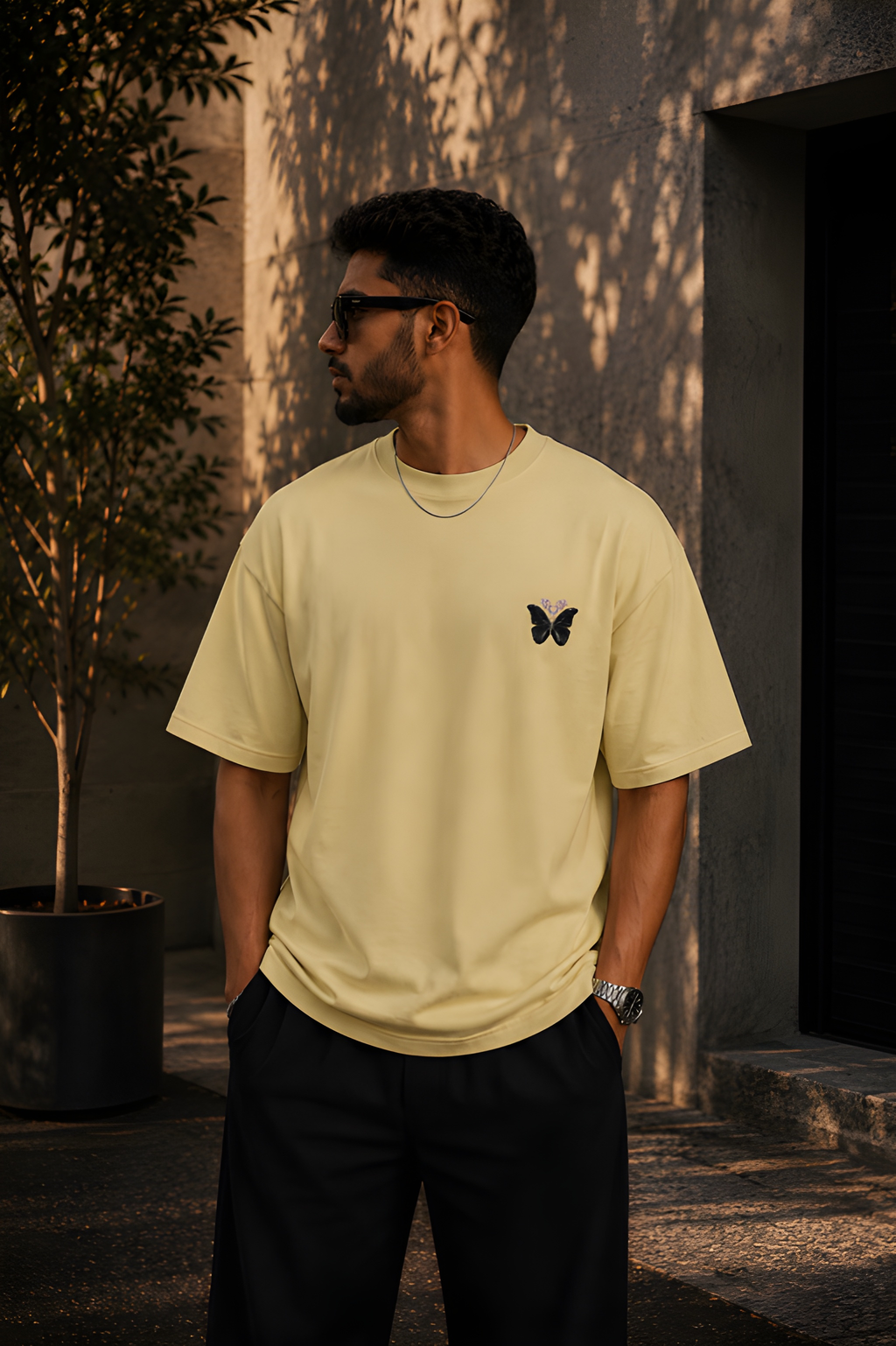 Antim Spread Kindness Like Wildflowers Oversized Beige T-Shirt Front Butterfly Chest Detail Male Model Outdoor Streetwear India